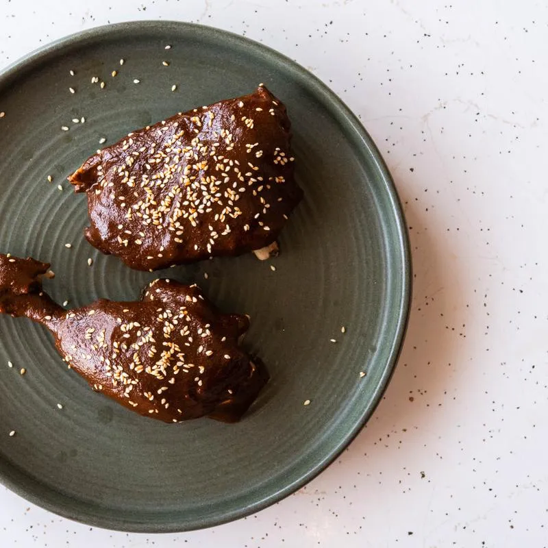 Mole plated over chicken and finished with sesame