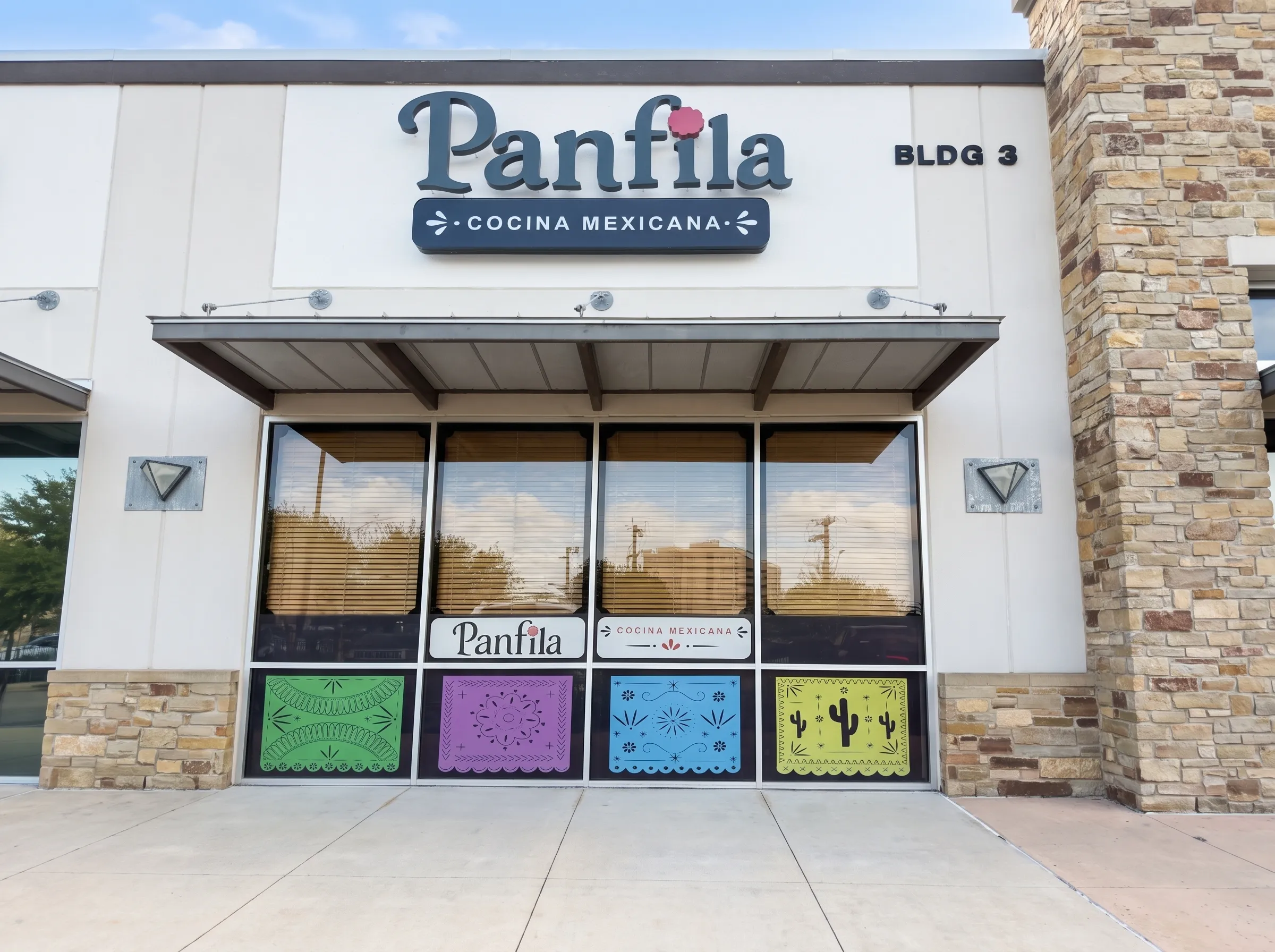Panfila Cocina Mexicana storefront with stone façade, red doors and papel-picado windows