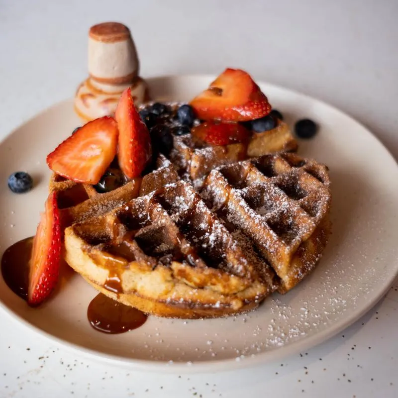 Waffle with honey, fresh strawberries and blueberries
